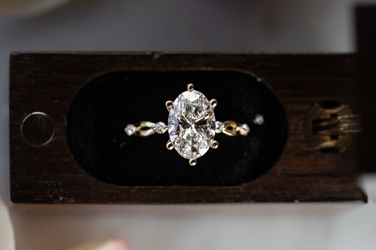 An oval engagement ring presented in its box.
